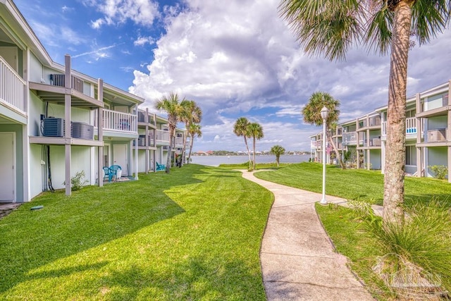 view of home's community with a water view and a yard