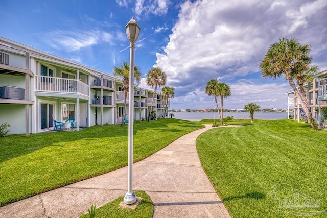 view of community featuring a water view and a yard