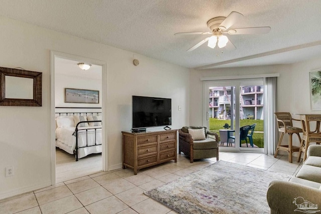 living room featuring light tile patterned flooring, a textured ceiling, and ceiling fan