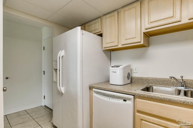 kitchen with light brown cabinetry, light tile patterned floors, sink, and white appliances