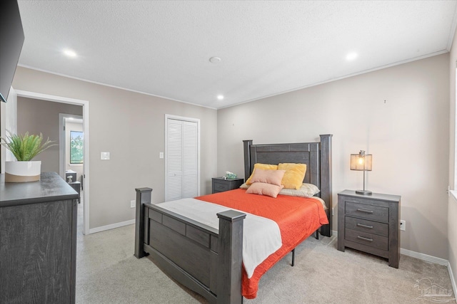 carpeted bedroom featuring a textured ceiling and a closet