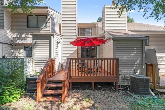 rear view of property with a wooden deck and central AC unit