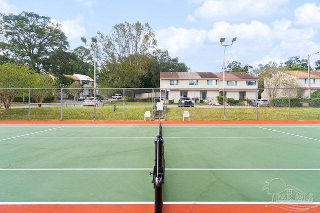 view of tennis court featuring a lawn