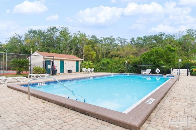 view of pool featuring an outbuilding and a patio area