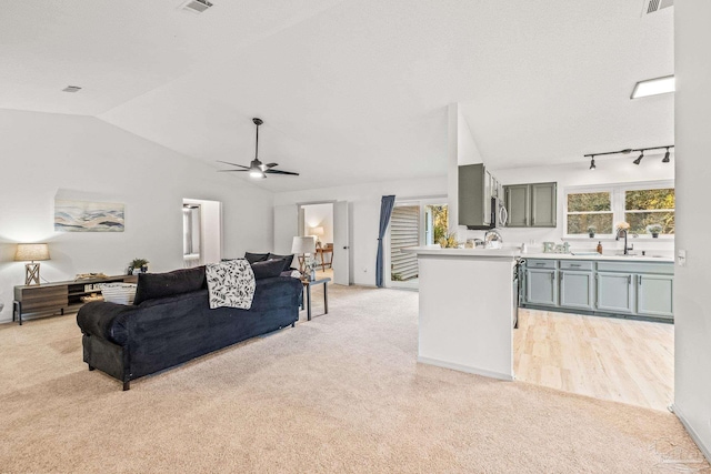 living room featuring light carpet, vaulted ceiling, plenty of natural light, and ceiling fan