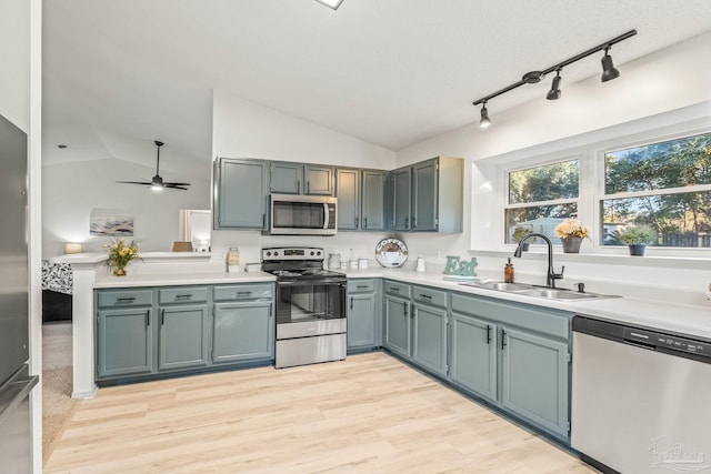 kitchen featuring sink, vaulted ceiling, ceiling fan, light hardwood / wood-style floors, and stainless steel appliances