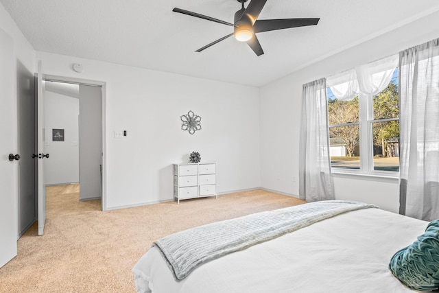 bedroom with ceiling fan and light colored carpet