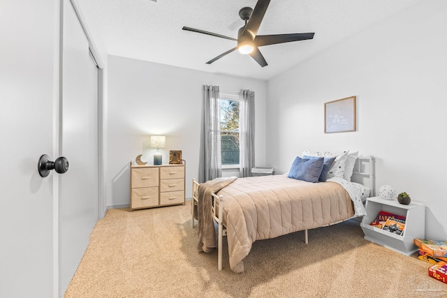 carpeted bedroom with ceiling fan and a textured ceiling