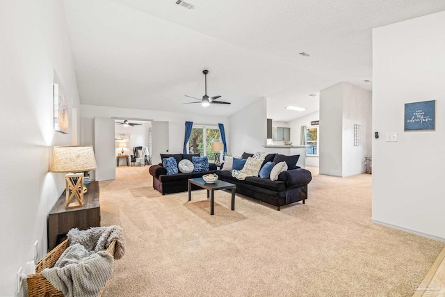 carpeted living room featuring ceiling fan and vaulted ceiling