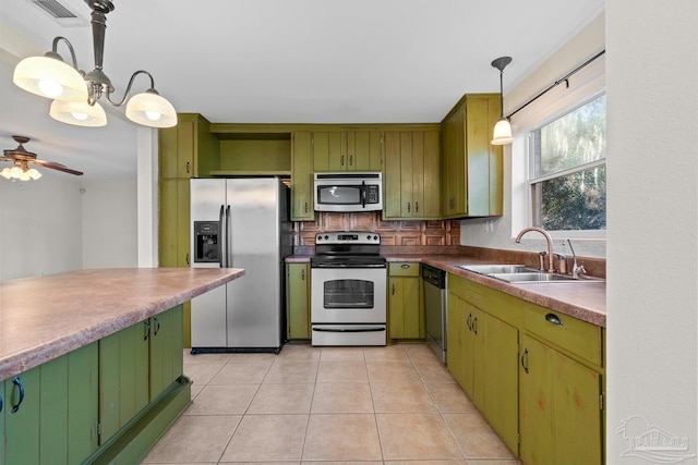 kitchen featuring green cabinets, stainless steel appliances, and a sink