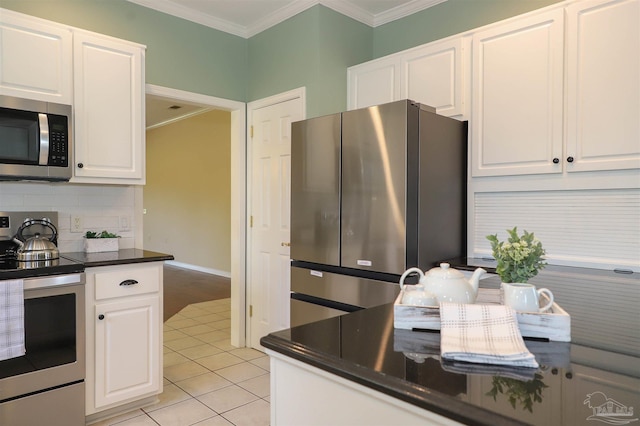 1200 Willowood Ln, Gulf Breeze, FL 32563 - kitchen featuring stainless steel appliances, white cabinets, crown molding, and dark countertops