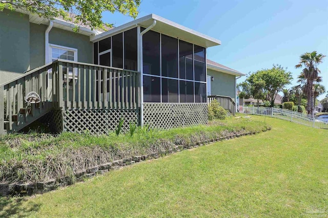 1200 Willowood Ln, Gulf Breeze, FL 32563 - rear view of property with fence, stucco siding, a sunroom, and a lawn