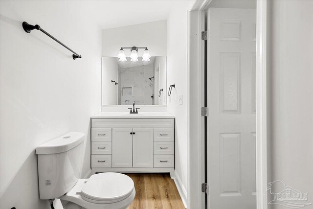 bathroom with vanity, hardwood / wood-style flooring, toilet, and vaulted ceiling