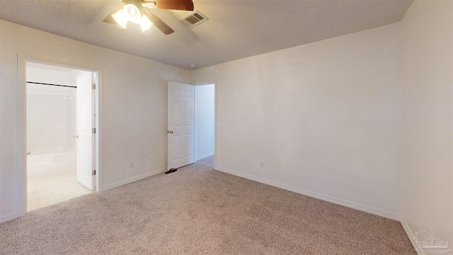 empty room with light carpet, baseboards, visible vents, and a textured ceiling