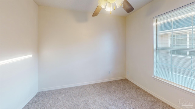 empty room with baseboards, a ceiling fan, and light colored carpet