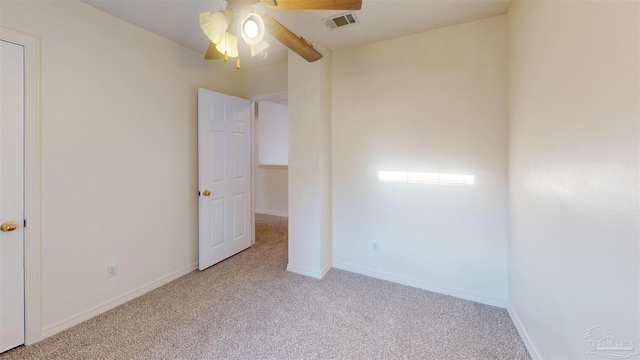 unfurnished bedroom featuring light carpet, ceiling fan, visible vents, and baseboards