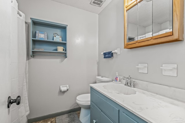 bathroom with vanity, a textured ceiling, and toilet