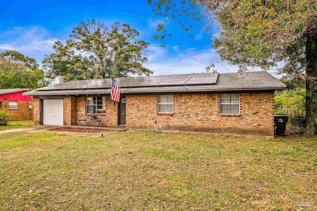 ranch-style house with a front yard, solar panels, and a garage