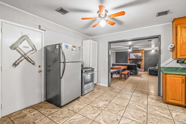 kitchen featuring ceiling fan, a brick fireplace, wood walls, appliances with stainless steel finishes, and ornamental molding