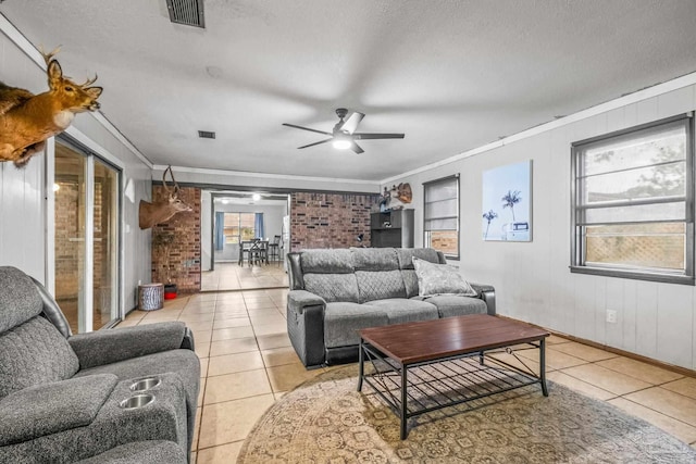 living room featuring ceiling fan, light tile patterned floors, and a textured ceiling