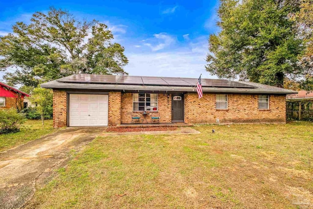 ranch-style home with a front lawn, a garage, and solar panels