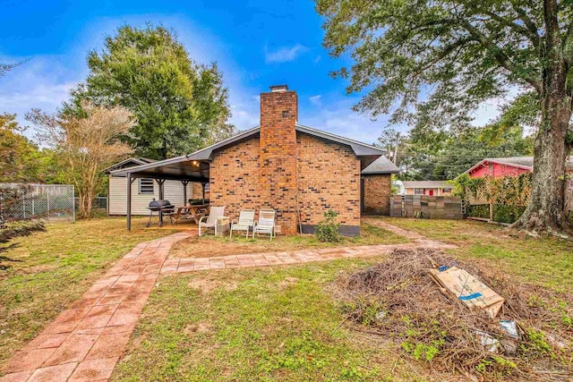 rear view of property with a lawn and a patio