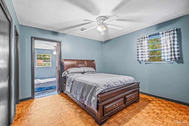 bedroom featuring ceiling fan, a textured ceiling, light parquet flooring, and multiple windows