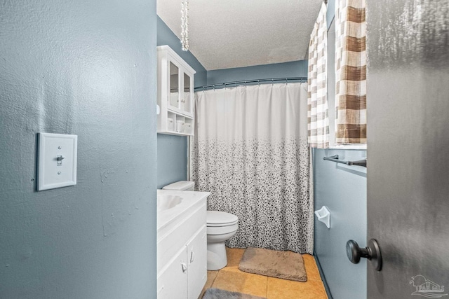 bathroom with tile patterned flooring, vanity, toilet, and a textured ceiling