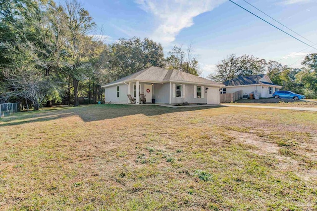 ranch-style home with a front yard and fence