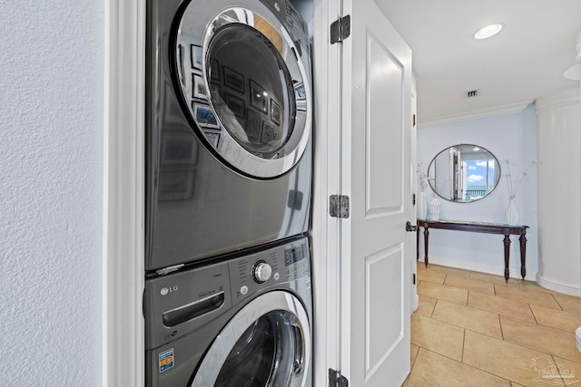 721 Pensacola Beach Blvd Unit 702, Pensacola Beach, FL 32561 - laundry room featuring stacked washer / dryer, ornamental molding, and light tile patterned flooring