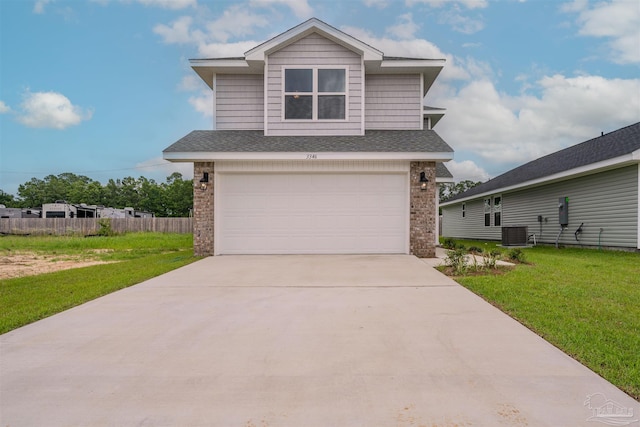 view of front of house with a garage, central AC unit, and a front yard