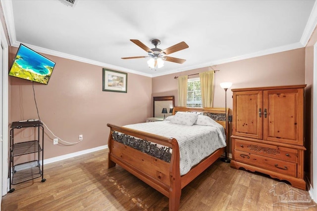 bedroom with crown molding, light wood finished floors, a ceiling fan, and baseboards