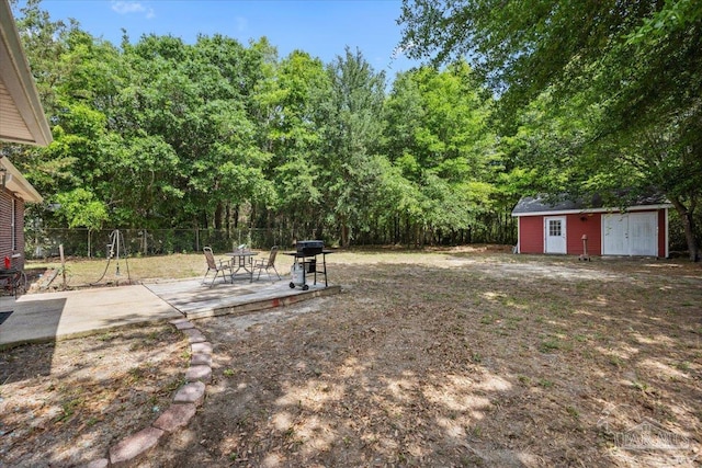 view of yard featuring fence, an outdoor structure, a storage unit, and a patio