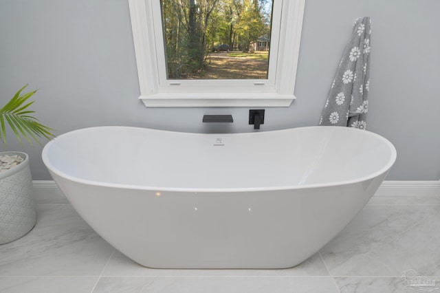 4900 Shell Rd, Milton, FL 32583 - bathroom featuring a soaking tub, marble finish floor, and baseboards