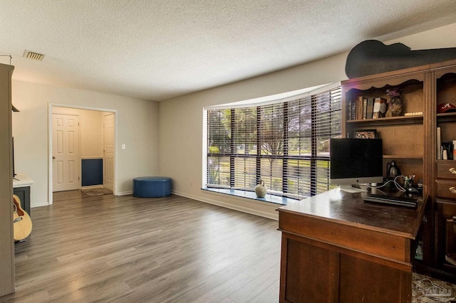 5945 Pamela Dr, Milton, FL 32570 - home office featuring a textured ceiling, wood finished floors, and baseboards