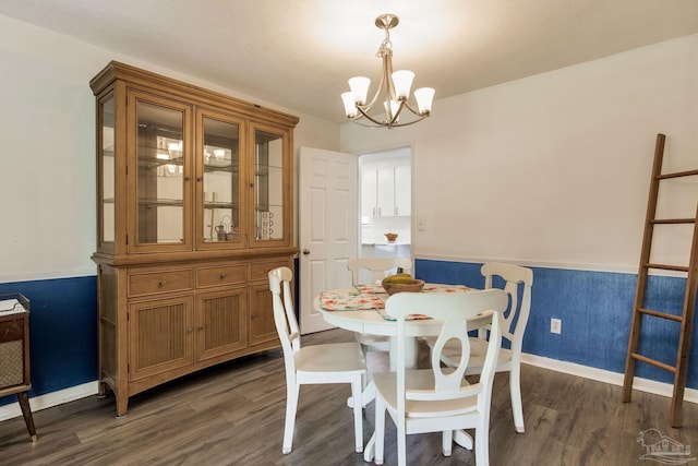 5945 Pamela Dr, Milton, FL 32570 - dining space featuring a chandelier, dark wood-style floors, wainscoting, and baseboards