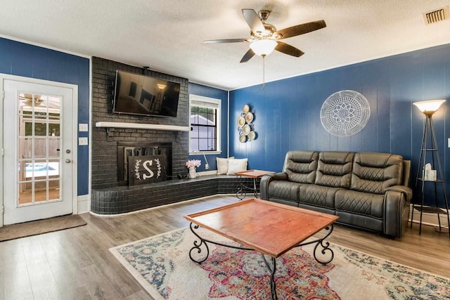 5945 Pamela Dr, Milton, FL 32570 - living room with a textured ceiling, ceiling fan, wood finished floors, and a fireplace