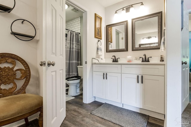 5945 Pamela Dr, Milton, FL 32570 - bathroom featuring toilet, wood finished floors, and double vanity