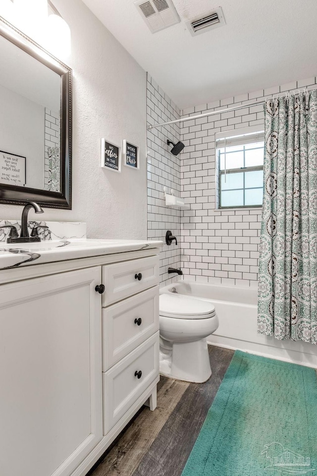 5945 Pamela Dr, Milton, FL 32570 - full bath featuring vanity, wood finished floors, toilet, shower / bathtub combination with curtain, and a textured wall