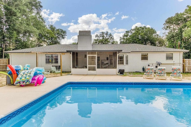 5945 Pamela Dr, Milton, FL 32570 - rear view of property featuring a sunroom, brick siding, a chimney, and roof with shingles