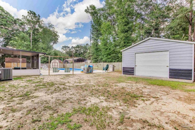 5945 Pamela Dr, Milton, FL 32570 - view of yard featuring central AC unit, a garage, and view of scattered trees