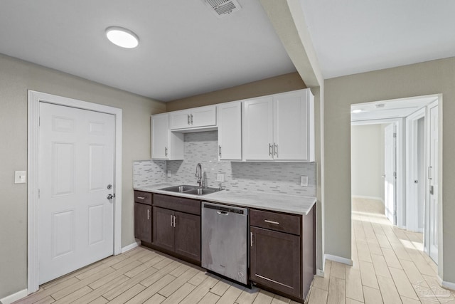 kitchen featuring decorative backsplash, dishwasher, white cabinets, and sink