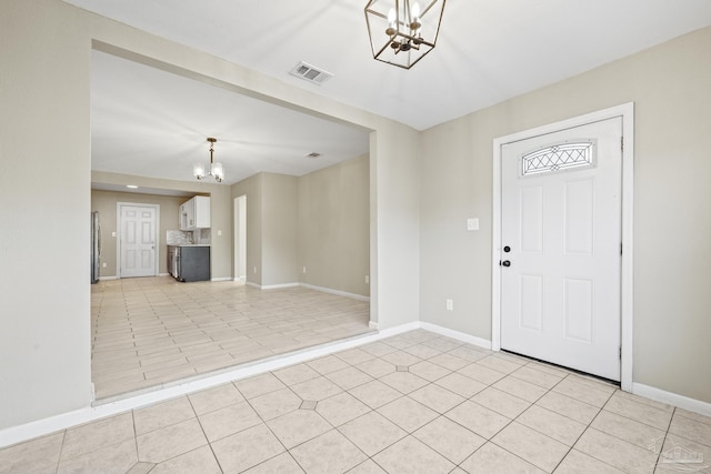 tiled entryway with an inviting chandelier