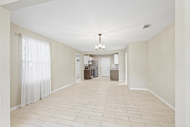 unfurnished living room with a chandelier