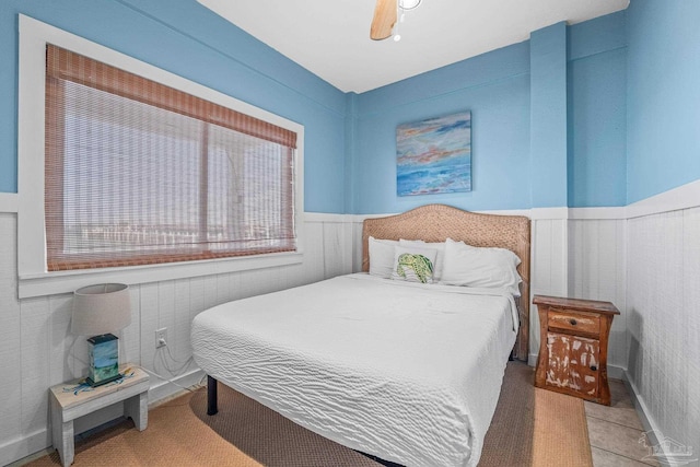 bedroom with ceiling fan and light tile patterned floors