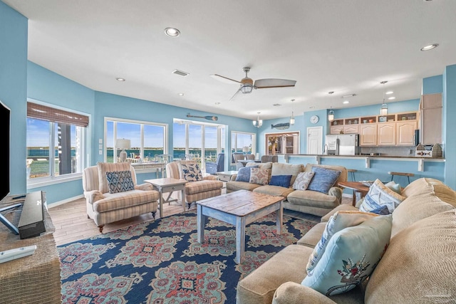 living room with light hardwood / wood-style flooring and ceiling fan