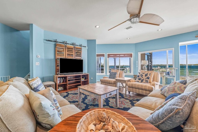 living room featuring a barn door and ceiling fan