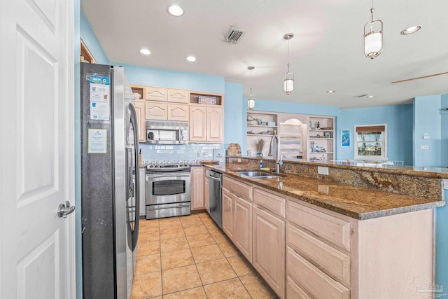 kitchen featuring pendant lighting, light brown cabinetry, sink, kitchen peninsula, and stainless steel appliances