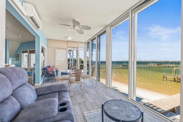 sunroom / solarium with a wealth of natural light, a wall mounted AC, and ceiling fan