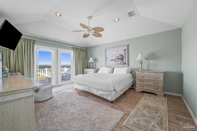 bedroom featuring hardwood / wood-style floors, vaulted ceiling, access to outside, and ceiling fan